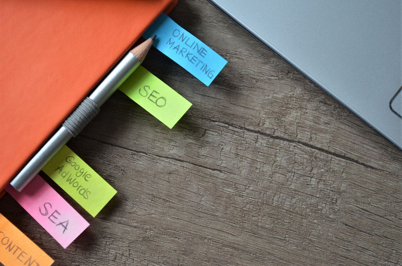 heros-img Close-up of SEO strategy planner with colorful sticky notes and a pencil on a notebook.